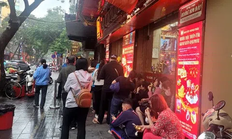 Người dân đội mưa xếp hàng chờ mua vàng trước ngày vía Thần Tài