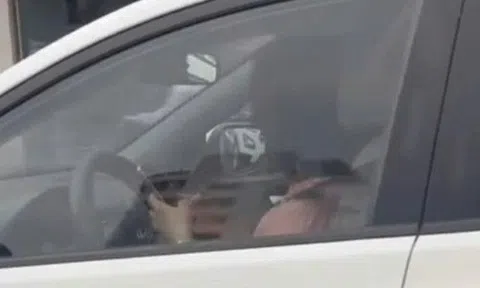 Nữ tài xế vừa lái xe vừa bấm điện thoại ở Hà Nội